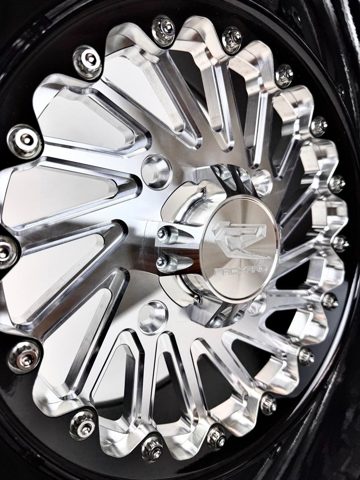 Close-up of a Packard Cyclone silver non-beadlock UTV wheel with a black barrel.