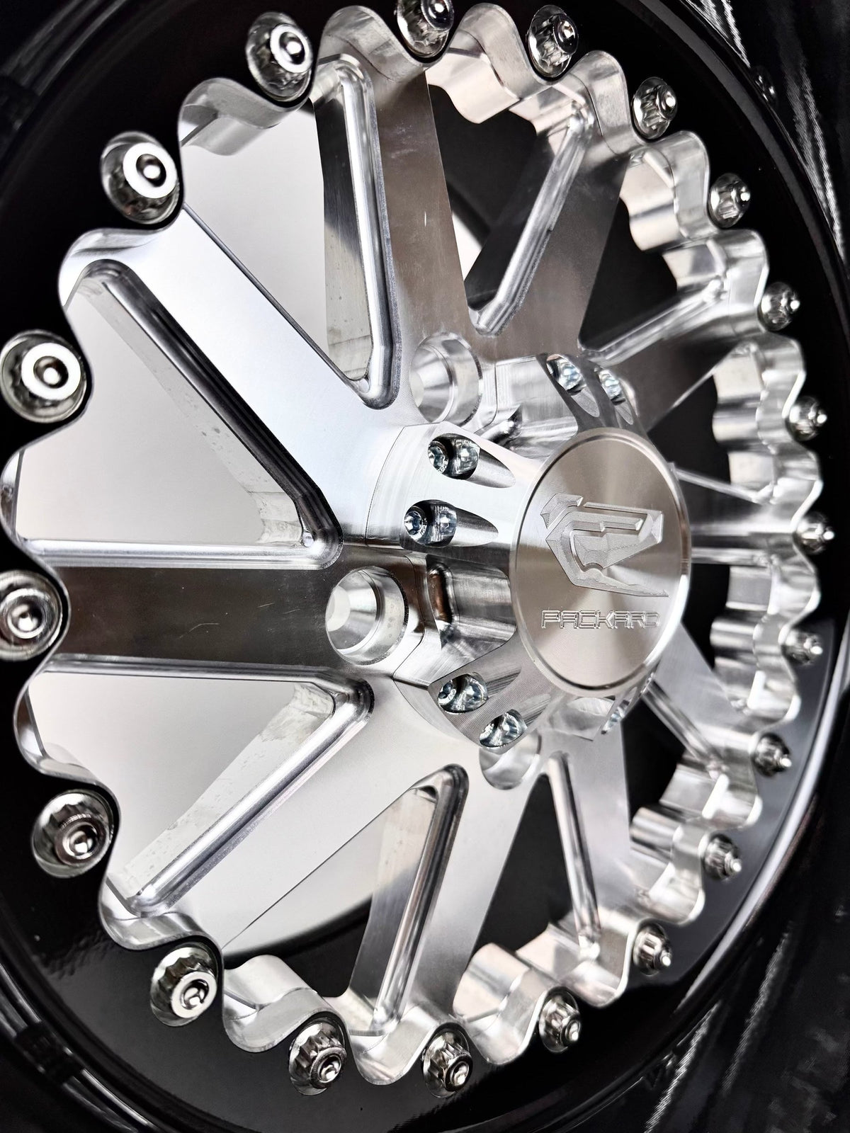 Close-up of a Packard Cyclone silver non-beadlock UTV wheel with a black barrel.