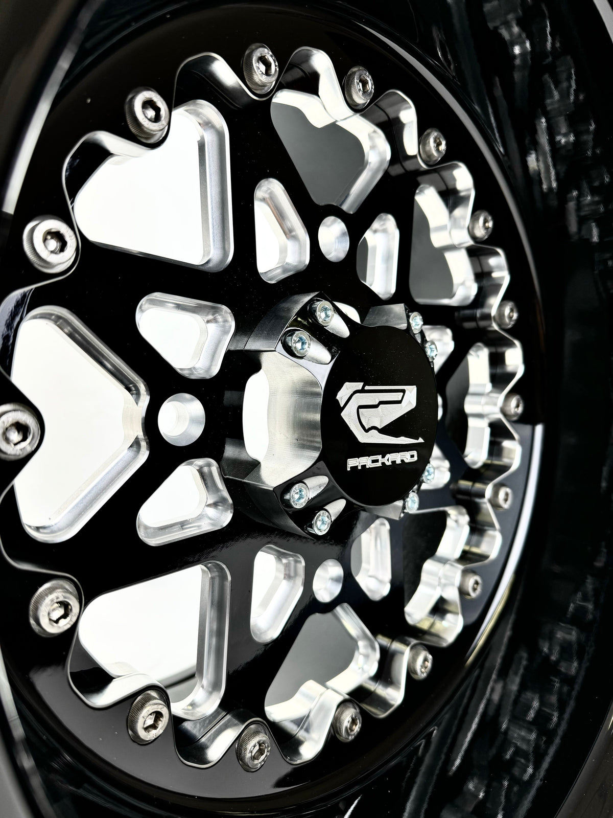 Close-up of a Packard V2 Super Star gloss black non-beadlock UTV wheel with a black barrel.