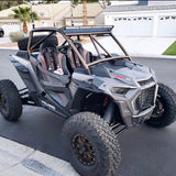 Manufacturer installation photo: red-accent Daytona seat pair in a gray Polaris RZR Turbo S; harnesses, vehicle and other accessories not included