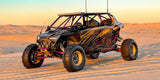 Hostile HF11 Boost wheels installed on a custom four-seat Polaris RZR at sunset in the sand dunes. Hostile gallery photo via Fastlab.