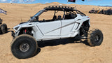 Hostile HF22 Rival rear wheels on a white Polaris RZR Pro R in the dunes; front wheels use a beadlock setup. Hostile manufacturer gallery.