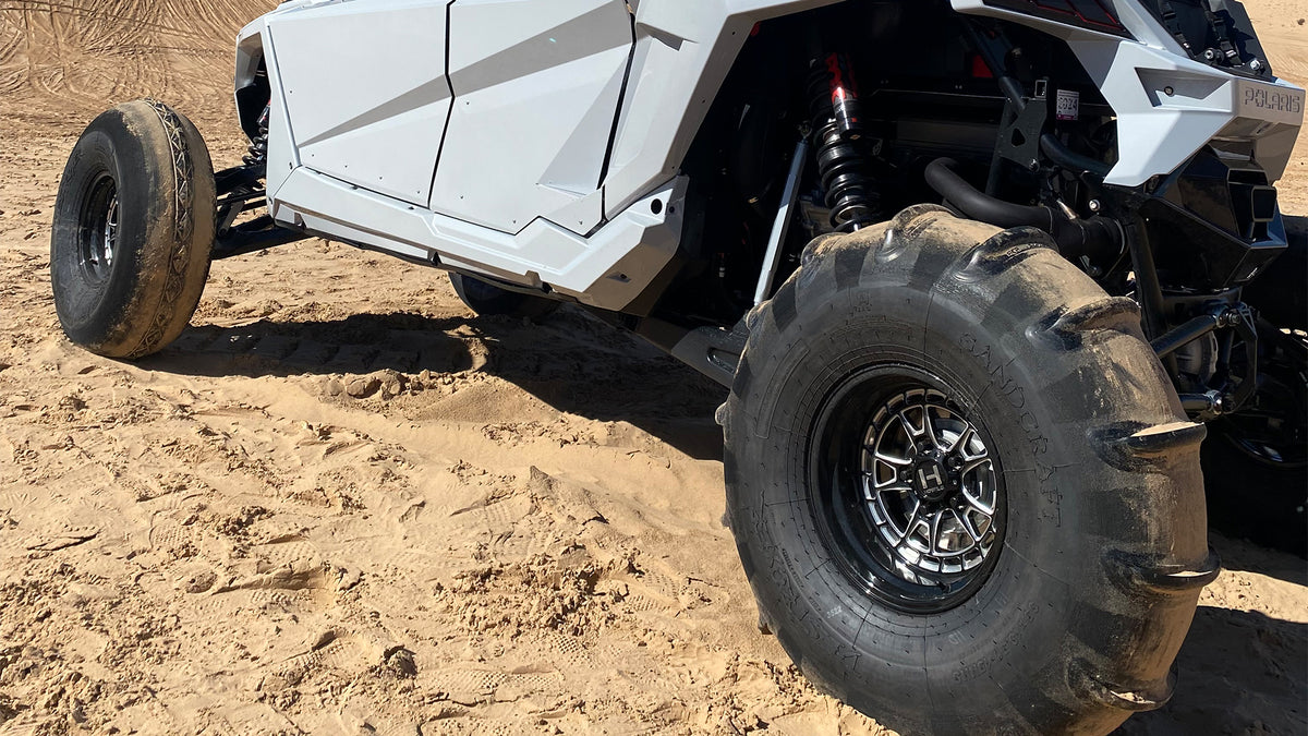 Installed Hostile HF22 Rival rear wheel close-up on a Polaris RZR Pro R with a sand paddle tire. Hostile manufacturer gallery.