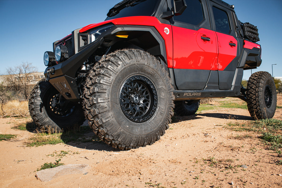 Close-up of Hostile H133 Glamis wheels installed on a red Polaris Xpedition. Hostile manufacturer gallery.