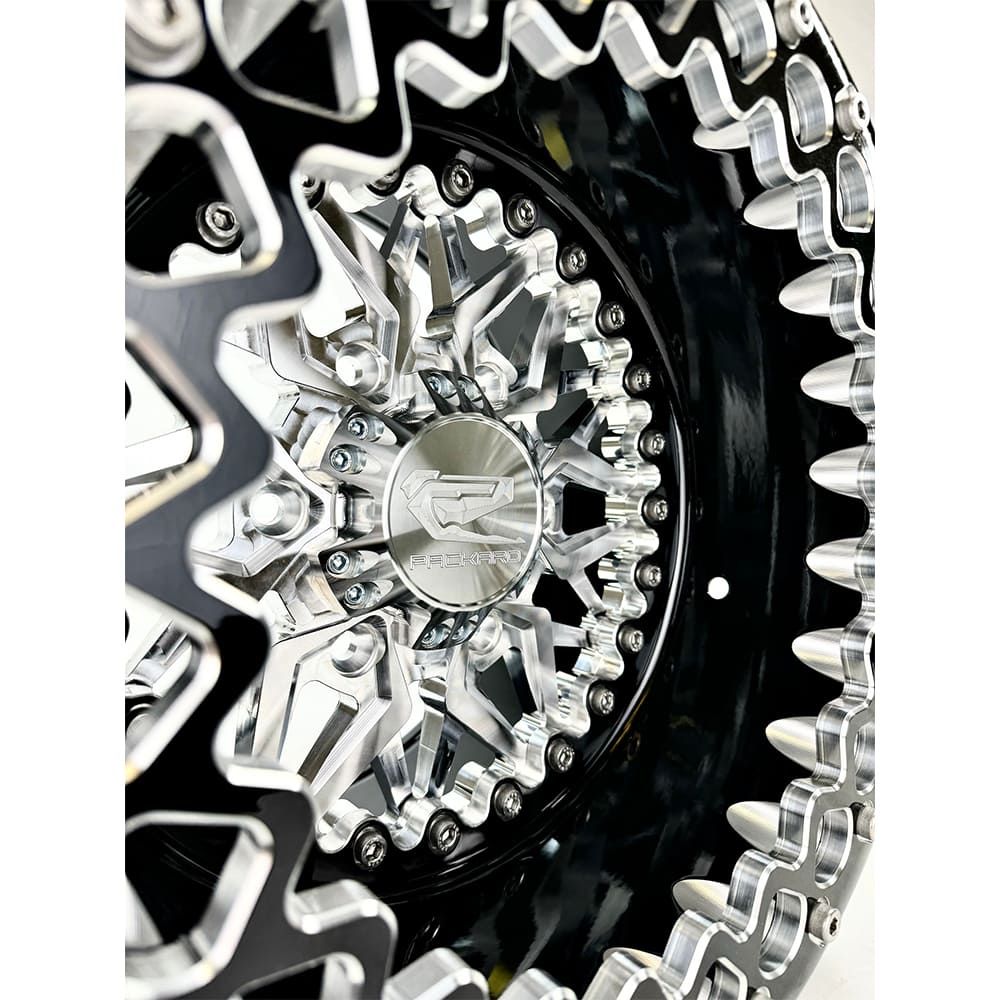 Close-up of a Packard Impact silver beadlock UTV wheel with a black barrel.
