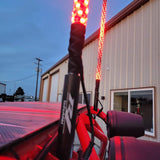 Red R1 LED whip lights illuminated on a UTV outside the R1 Industries shop
