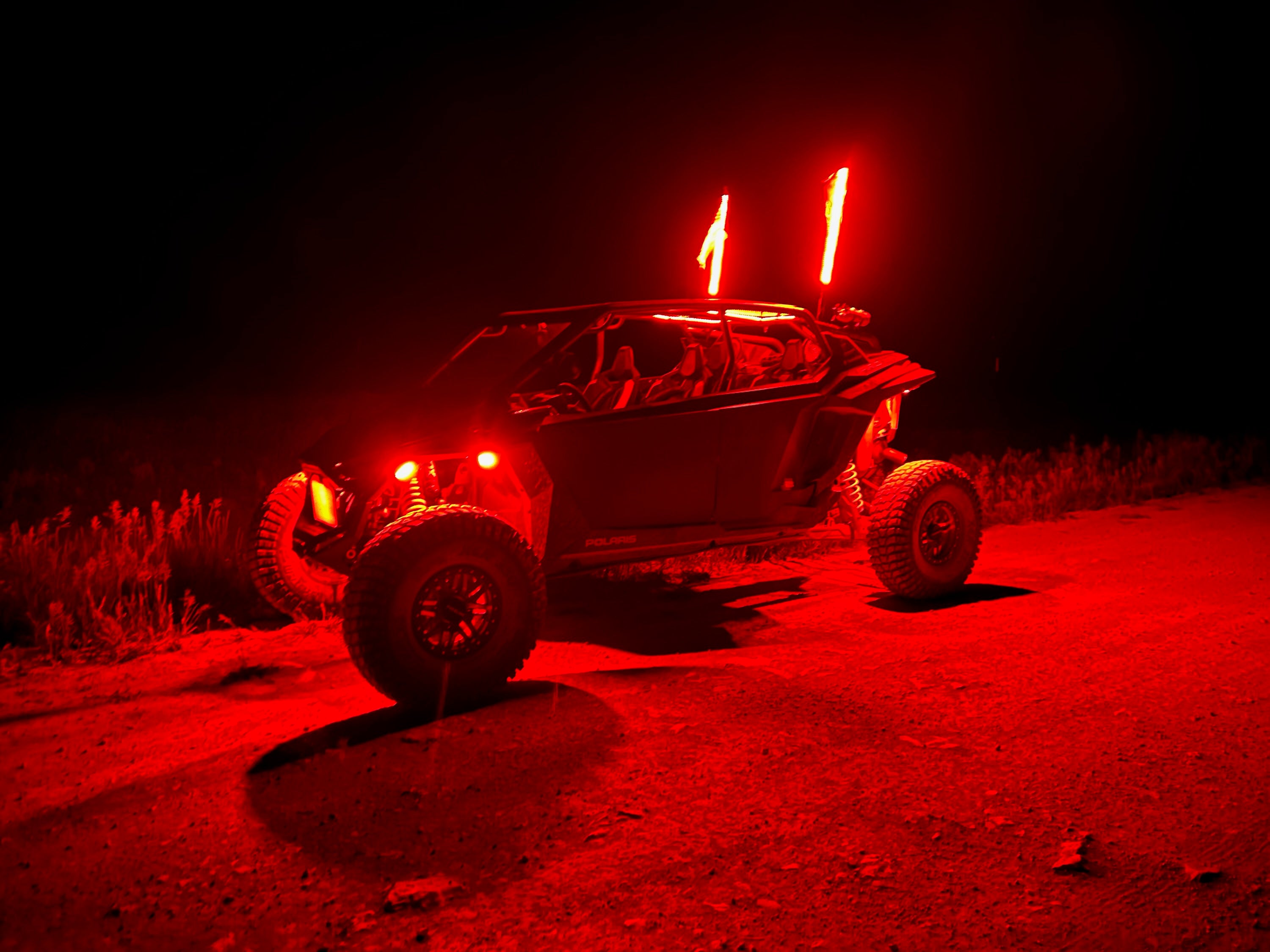 Off-road vehicle with red lights on a dark background